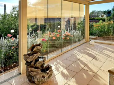 Referenz - Glashaus mit rahmenloser Schiebeverglasung und außenliegender Sonnenschutz