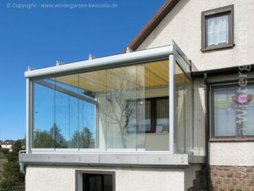 Glashaus auf einem Balkon mit Glasschiebeelementen und innenliegendem Sonnenschutz